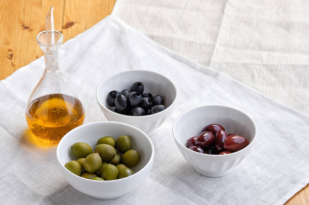 Various kinds of olives and olive oil - Фото, зображення