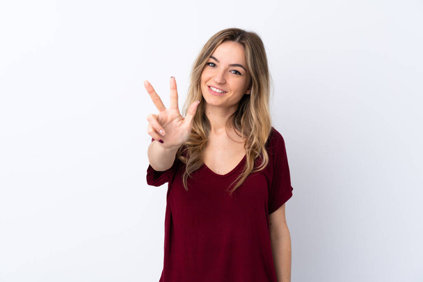 Νεαρή γυναίκα πάνω από απομονωμένο λευκό φόντο ευτυχισμένη και καταμέτρηση τρία με τα δάχτυλα - Φωτογραφία, εικόνα
