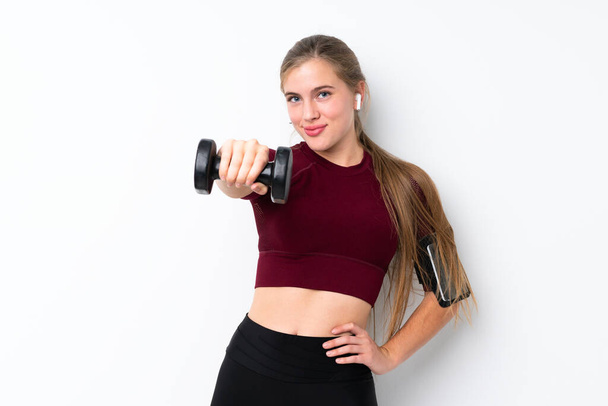 Sport teenager girl over isolated white background making weightlifting - 写真・画像