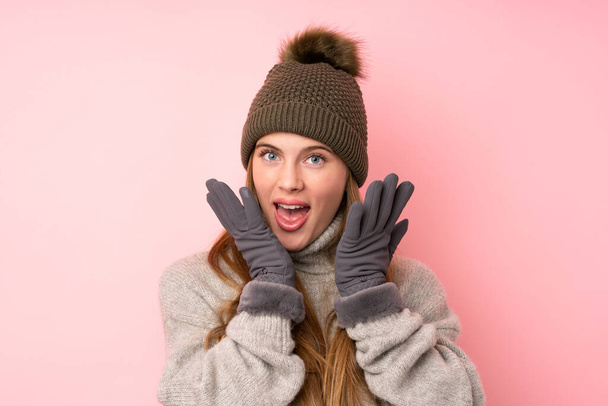 Young teenager girl with winter hat over isolated pink background with surprise facial expression - Foto, afbeelding