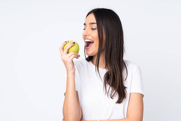 Mujer joven caucásica aislada sobre fondo blanco comiendo una manzana - Foto, Imagen