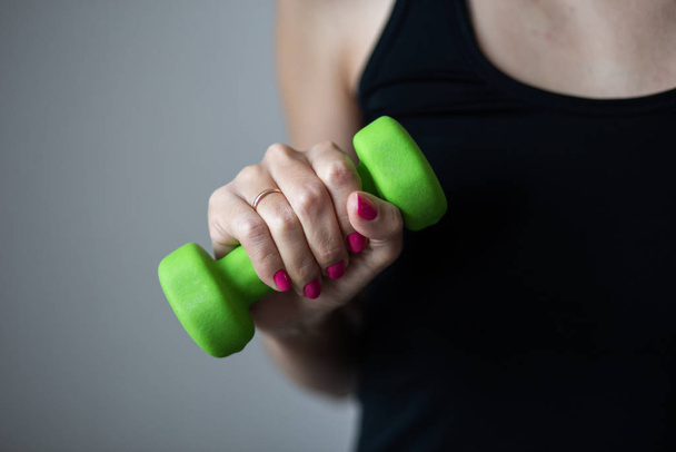 Woman holds a small dumbbells, close up photo, sport and recreation - 写真・画像