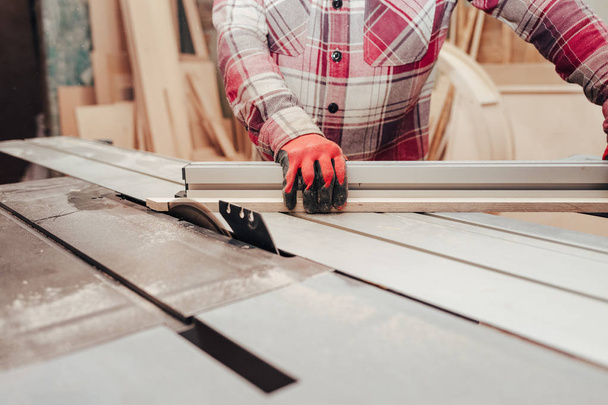 Carpenter cuts plywood on a circular saw - Photo, Image