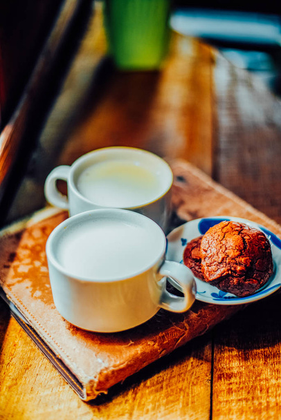 Duas xícara de café de cappuccino e biscoitos Brownie na mesa de madeira, café de rua, vista superior
. - Foto, Imagem