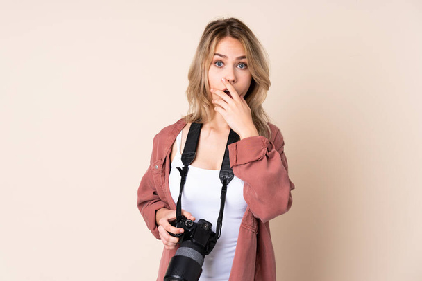 Mladý fotograf dívka přes izolované pozadí překvapen a šokován při pohledu vpravo - Fotografie, Obrázek