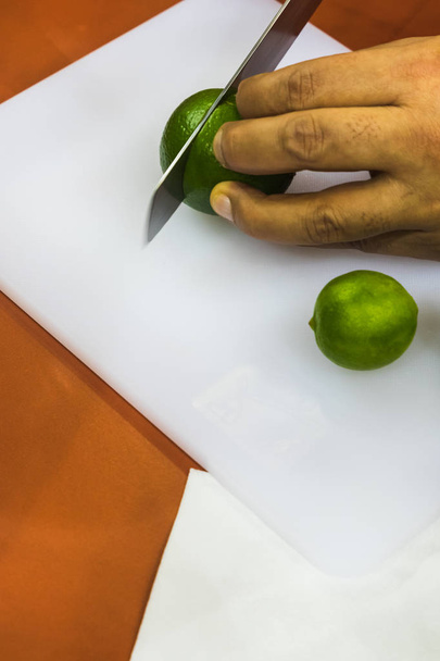 Un Latino Maschio Affettare a mano frutta su vassoio bianco - Foto, immagini