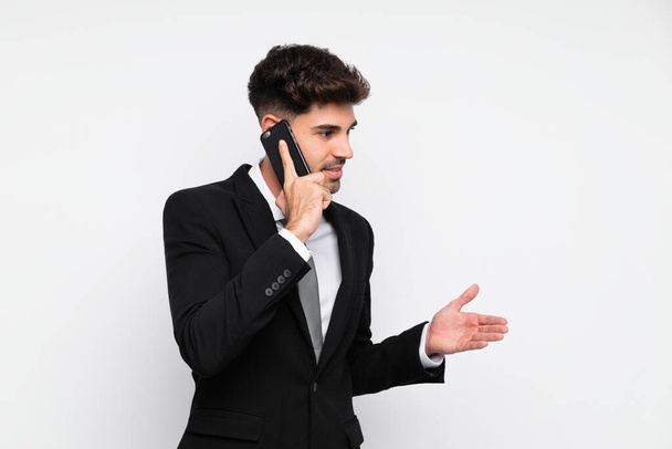 Молодий бізнесмен з мобільним телефоном над ізольованим білим тлом
 - Фото, зображення