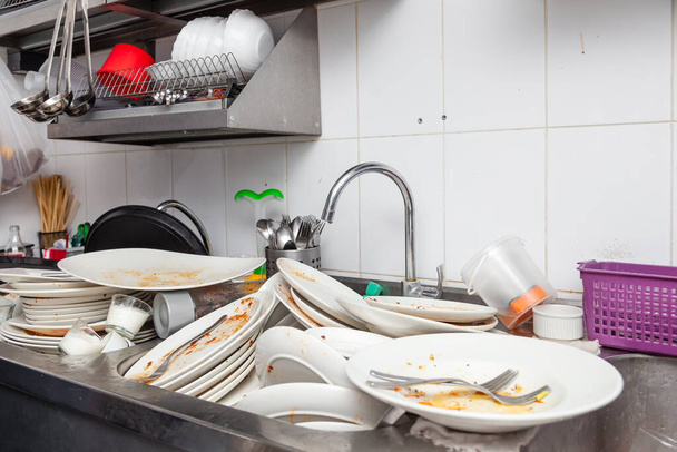 Μεταλλικός νεροχύτης γεμάτος βρώμικα πιάτα, πιατικά, επιτραπέζια σκεύη - Φωτογραφία, εικόνα