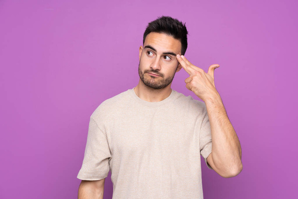Young handsome man over isolated purple background with problems making suicide gesture - Φωτογραφία, εικόνα