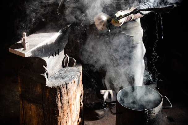 Kovácsműhely kovácsolási folyamat - Hűtés ki egy elemet a vödör hideg víz - Fotó, kép