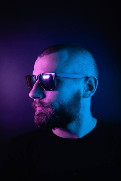 Portrait of a hipster guy with color light. Hipster face portrait in studio. - Foto, imagen