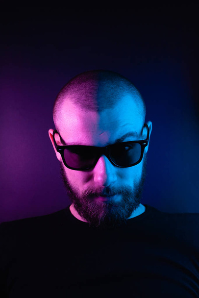 Portrait of a hipster guy with color light. Hipster face portrait in studio. - Foto, Imagem