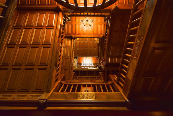 A low angle shot of the interior of a wooden building, including the staircases and the ceiling - Photo, image