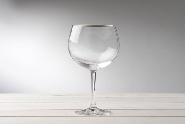 Empty glass of gin or broad on white wooden table, elengance - Фото, изображение
