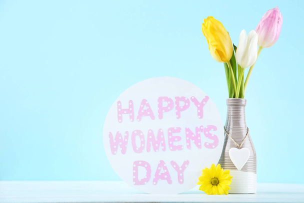Text Happy Womens Day with tulip flowers on blue background - Φωτογραφία, εικόνα