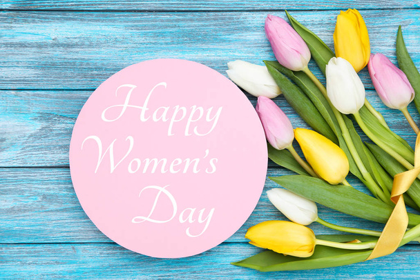 Texto para mujer Día con flores de tulipán en mesa de madera azul
 - Foto, imagen