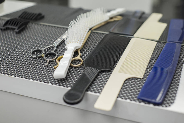 set of various professional barber tools and mirror in barbershop Closeup of a hairdresser at the workplace. Closeup of a hairdresser at the workplace. On the table are combs and hair clippers. Barbershop. Haircut beard and hair on the head. Table wi - Photo, Image