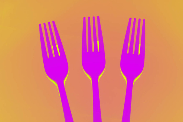 Kunststoffgabel auf farbigem Hintergrund; Gabel für Casual Food, weiß bezogen zum Stechen und Zubereiten von Casual Food, ideal für Familienessen, Partys, Catering. - Foto, Bild