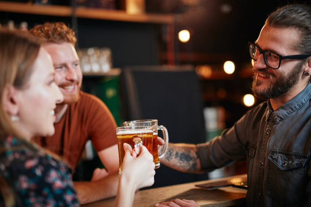 Couple caucasien debout dans le pub, griller avec de la bière et s'amuser. Vie nocturne
. - Photo, image