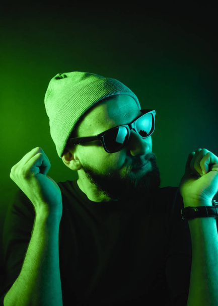 Portrait d'un hipster avec lumière de couleur. Portrait visage hippie en studio
. - Photo, image