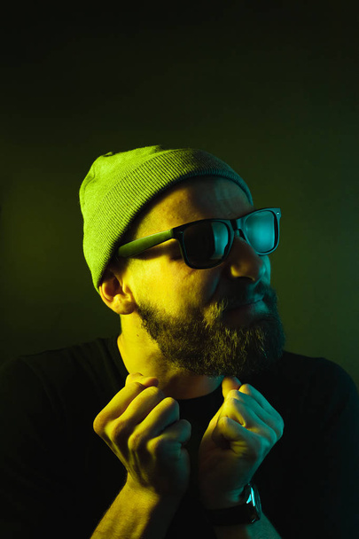 Portrait of a hipster guy with color light. Hipster face portrait in studio. - Valokuva, kuva