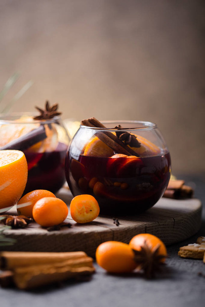 Christmas mulled wine  in circle glasses delicious holiday like parties with orange cinnamon star anise spices. Traditional hot drink in circle glasses or beverage, festive cocktail at X-mas or New Year - Фото, зображення