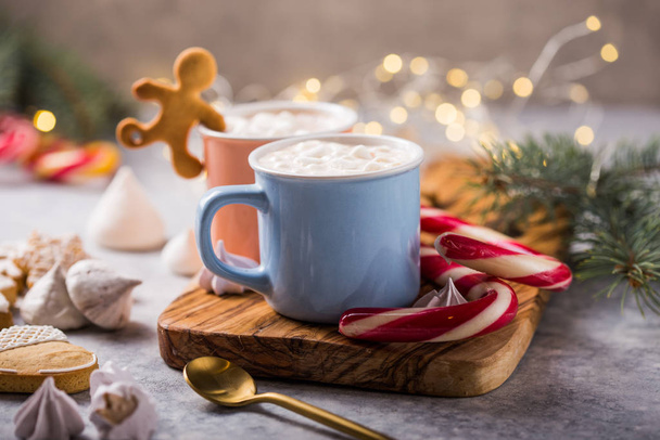 Горячий шоколад какао напитки с зефиром в рождественских кружках на сером фоне. Традиционный горячий напиток, праздничный коктейль на Рождество или Новый год
 - Фото, изображение