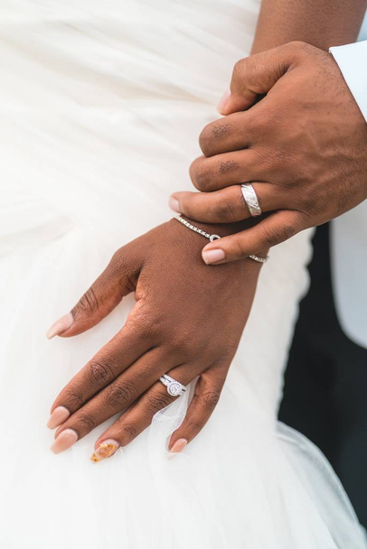A closeup shot of a bride and and a groom's hand with wedding rings - Foto, Imagem