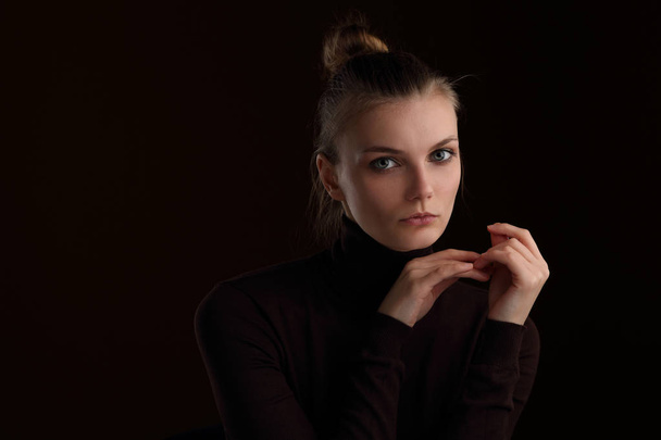 Studio portrait of a beautiful slender girl in a maroon turtleneck on a brown background - Fotoğraf, Görsel