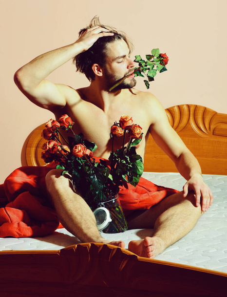 bearded macho man with roses in transparent vase - Фото, изображение