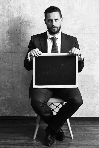 businessman or serious man holding a blackboard - Fotó, kép
