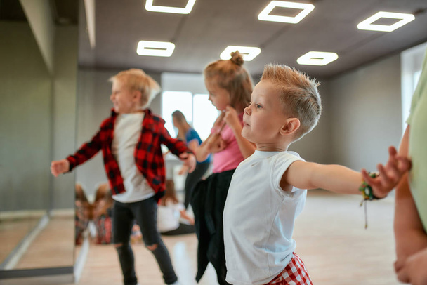 Modern dancers. Group of fashionable children learning a modern dance while having a choreography class. Dance studio - Φωτογραφία, εικόνα