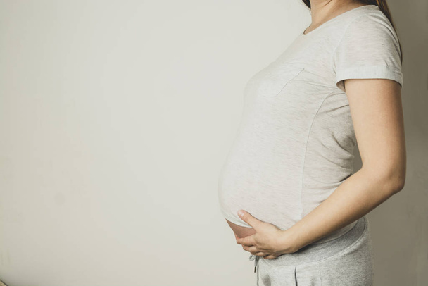 Pregnant woman with her hands on her belly, close up, copy space for text. - Fotoğraf, Görsel