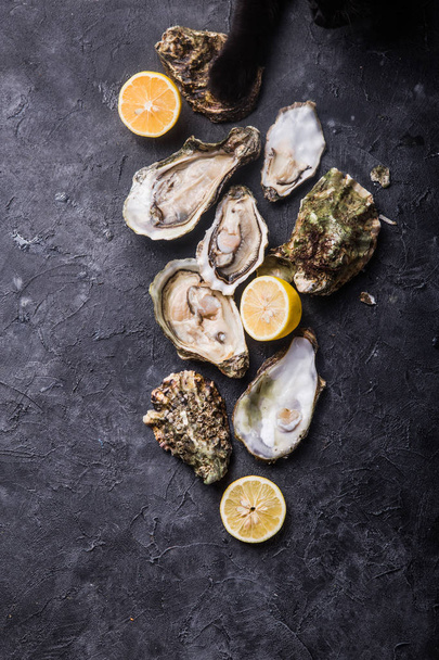 Fresh open Oysters. Healthy sea food. Dinner in restaurant. Gourmet food. Dark background. Top view - Fotó, kép