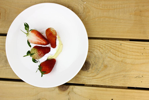 copyspace with tasty strawberries in cream on wooden table  - 写真・画像