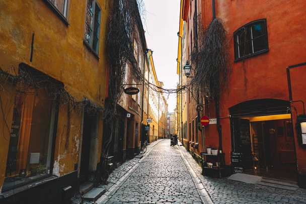 14 February 2020, Stockholm Sweden. Beautiful cozy narrow street in Gamla Stan - old town of Stockholm. Historic european facades of buildings - 写真・画像
