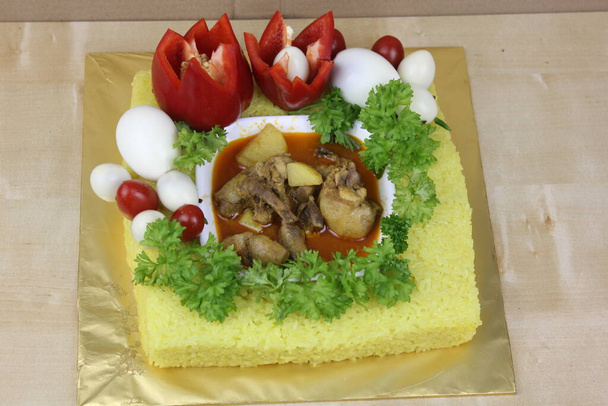 Малайська страва з жовтим глузливим рисом, овочами та м'ясом. - Фото, зображення