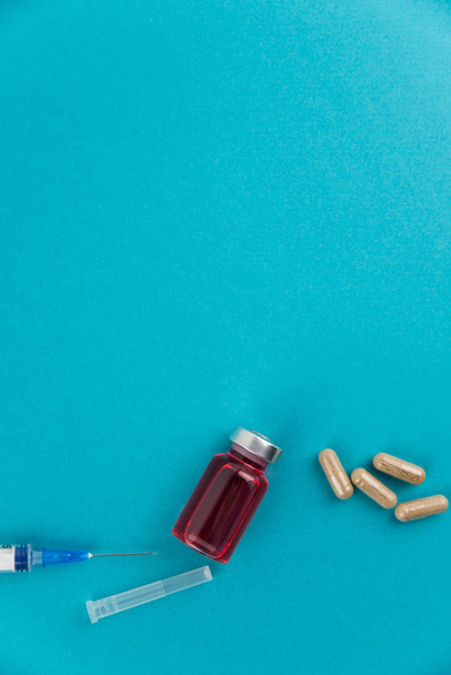 Medicine bottle for injection. Medical glass vials, syringe and drug pills for vaccination. Liquid red drug or vaccine for treatment, flu in laboratory, hospital, healthcare, or pharmacy concept, isolated. - 写真・画像
