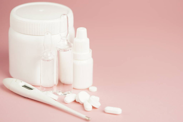 White medical pills and medical preparations in with bottles, glass ampoues,close-up on pink background. Closeup photo of medical preparations with copy spaes. - Foto, imagen
