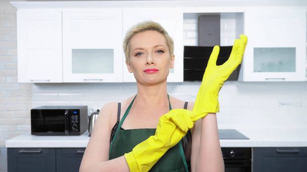  humor. woman in leather corset, puts on rubber gloves. cleaning - Fotografie, Obrázek