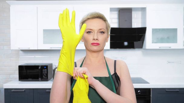  humor. woman in leather corset, puts on rubber gloves. cleaning - Foto, immagini