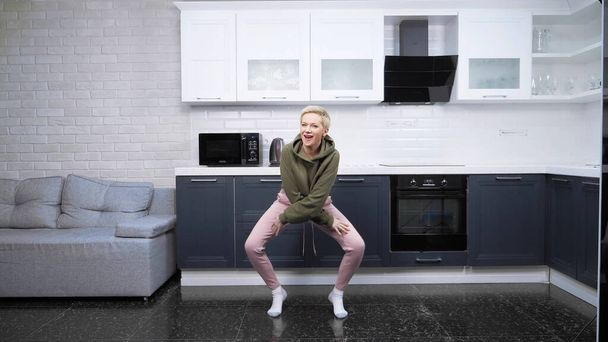 stylish young woman dancing at home in the kitchen - 写真・画像