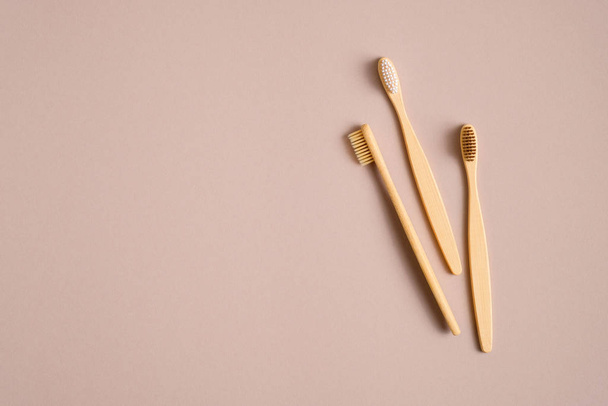 Bamboo wooden toothbrushes on brown background. Eco-friendly, plastic free, zero waste dental tool concept. Flat lay, top view. - Foto, afbeelding