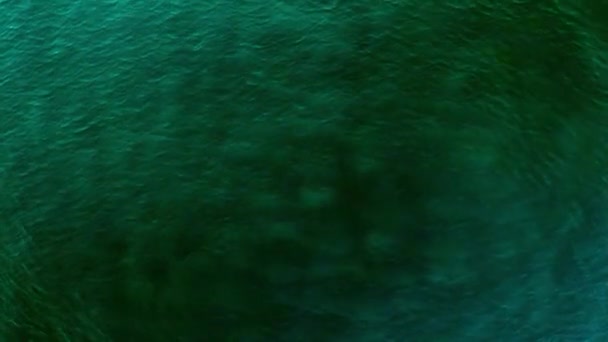 Aérea Sobre la tranquila superficie del agua del océano con ondulaciones azules del mar y olas movimiento lento con rayo de luz solar reflejo del rayo de sol
 - Metraje, vídeo