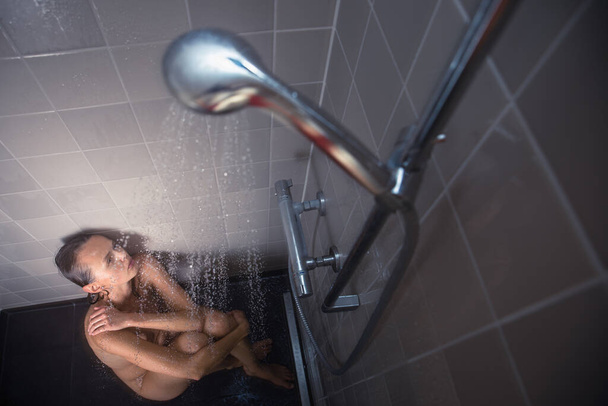 Pretty, young woman taking a long hot shower washing her hair in a modern design bathroom - Fotoğraf, Görsel