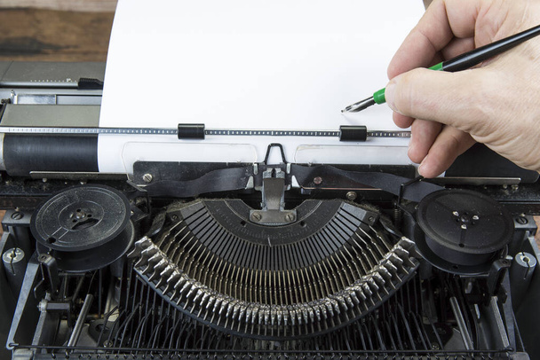 Stara maszyna do pisania z lat siedemdziesiątych z papierem i przestrzenią do kopiowania. Z ręką na piśmie.. - Zdjęcie, obraz