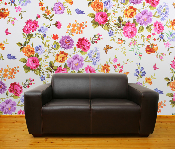 Interieur mit braunem Ledersofa gegen bunte Blumenwand - Foto, Bild