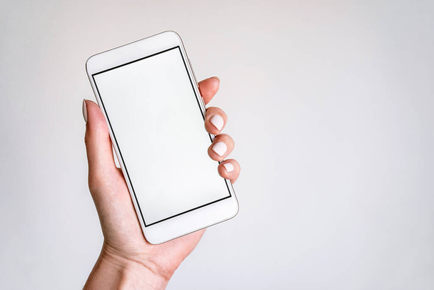 Жіноча модель рук з білим мобільним телефоном з білим екраном на ізольованих технологіях макетів фону
 - Фото, зображення