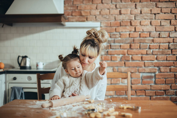Mother and daughter baking cookies in their kitchen - Фото, изображение