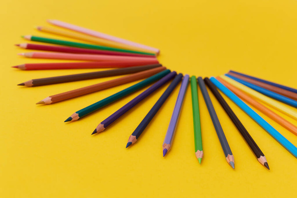 Composition de nombreux crayons multicolores sur fond jaune
 - Photo, image
